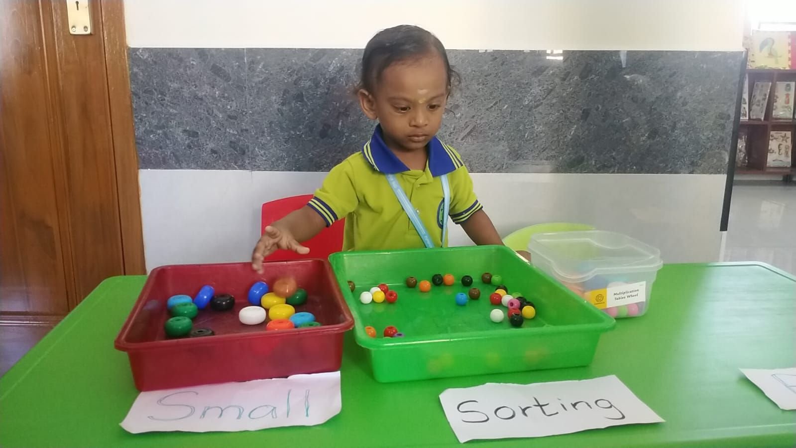 A student sorting beads by size and colour