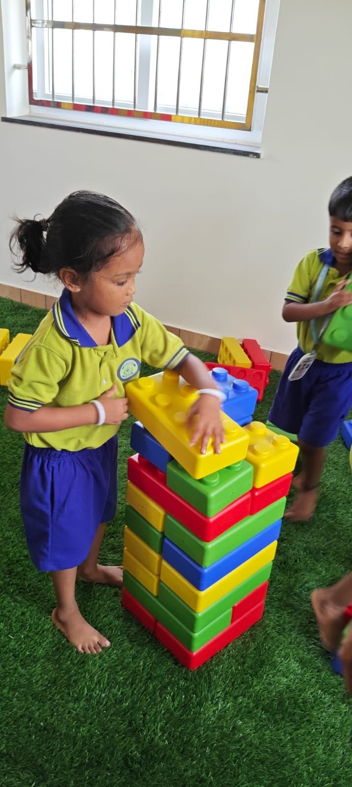 A student stacking a colourful block tower