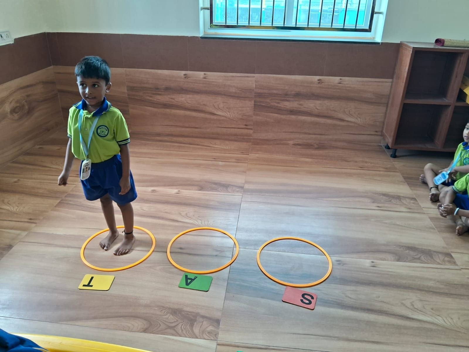 A student hopping through letter-hoop phonics activity